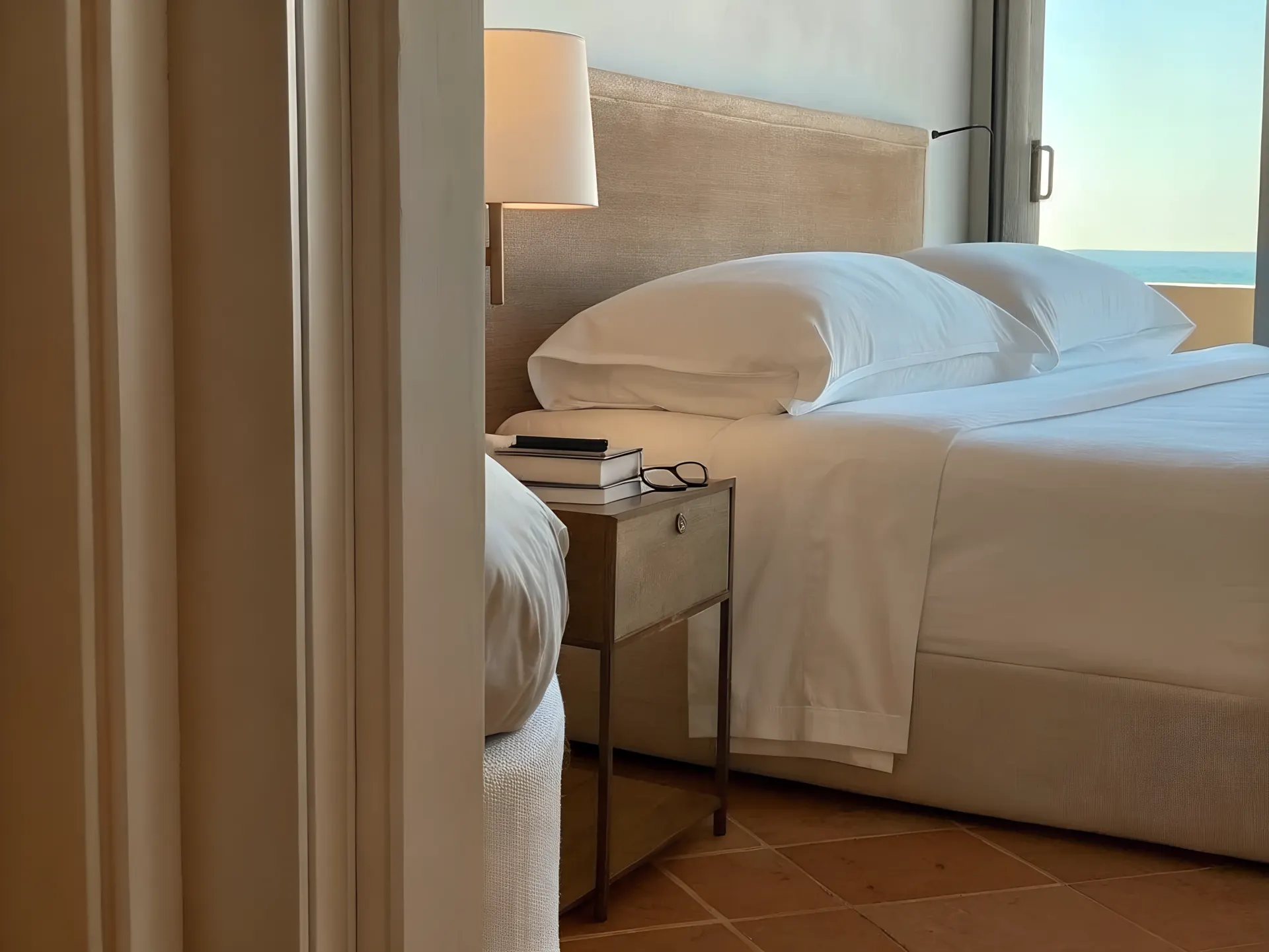 A villa bedroom with sea view and bedside reading
