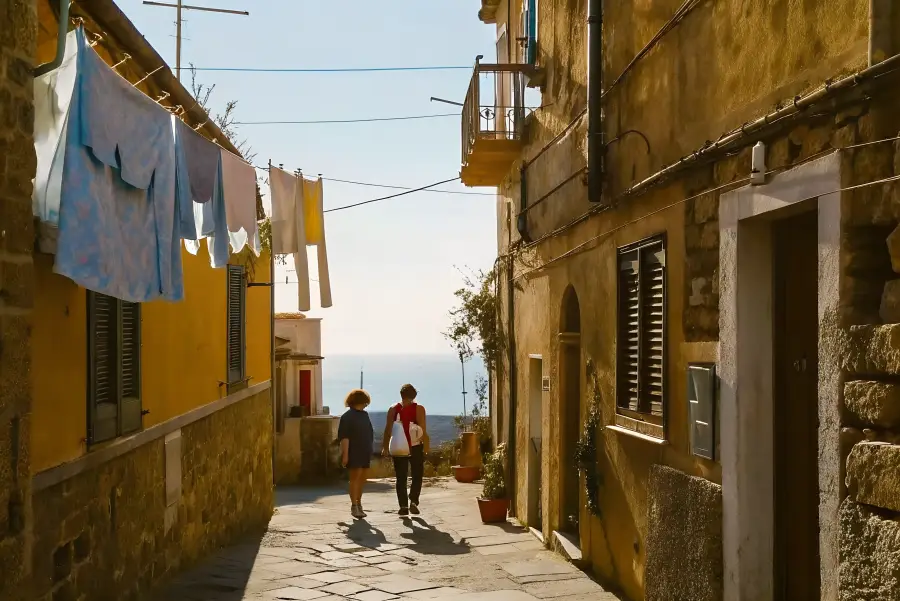 Two people walking a sunlit Tropea alley